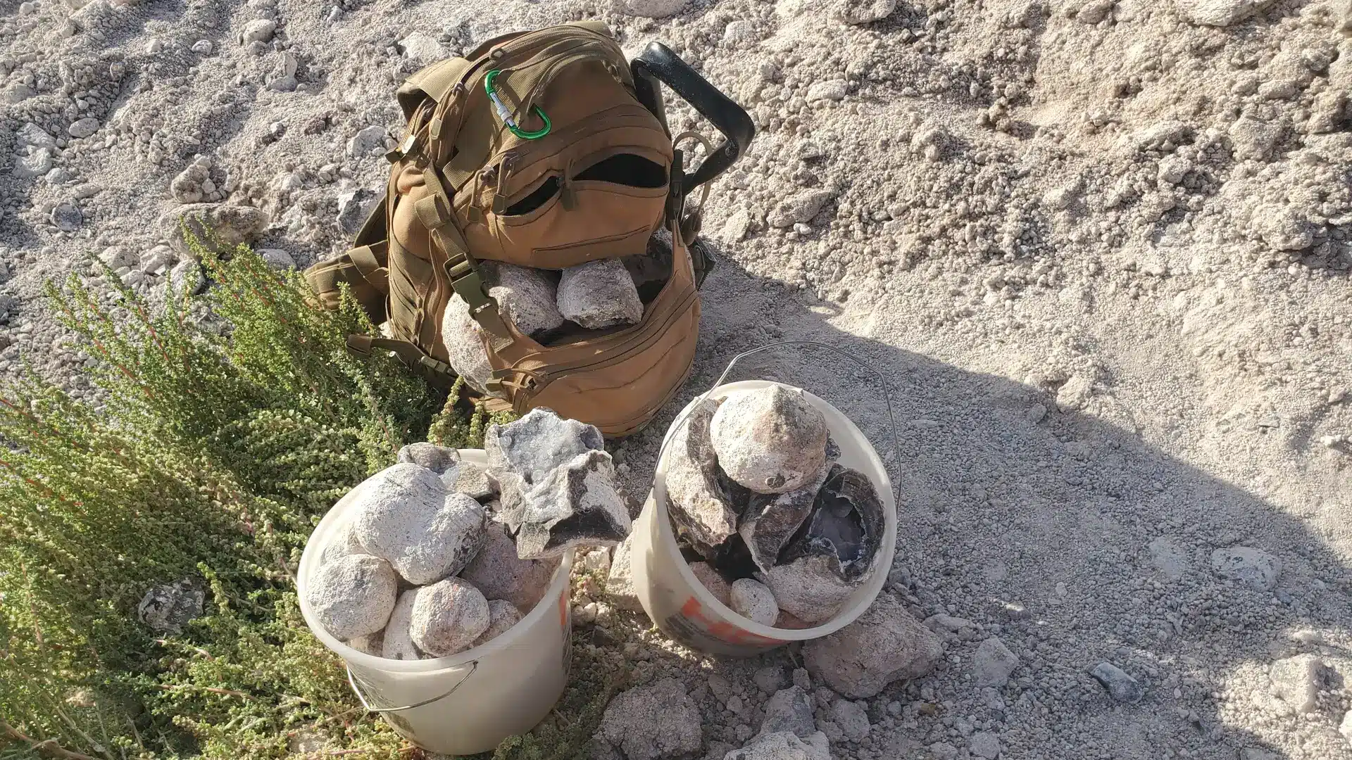 Zelf op zoek naar edelstenen. Een rugzak en twee emmers vol gevonden stenen.